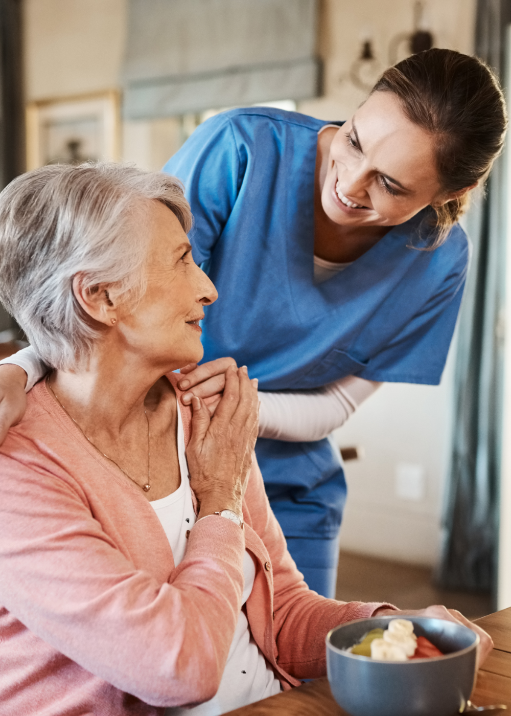 Caregiver talking with smiling senior woman