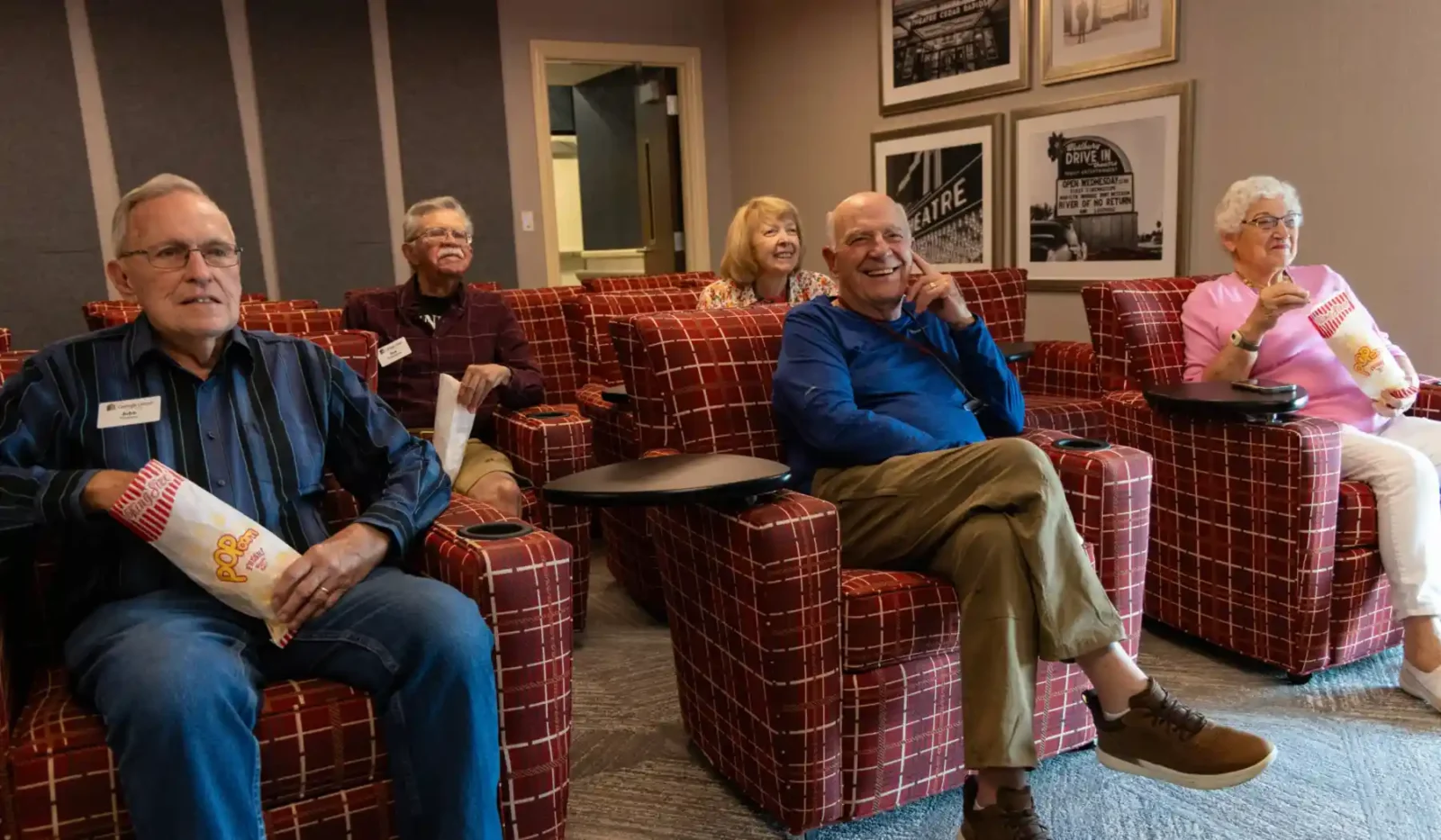 Theater room at Cottage Grove Place senior living community with large screen and comfortable seating