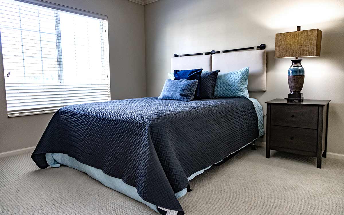 Bedroom inside a Cottage Grove Place senior apartment with cozy decor