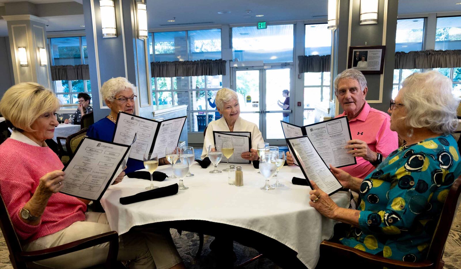 Friends gathered around a table at Cottage Grove Place sharing a meal and laughter