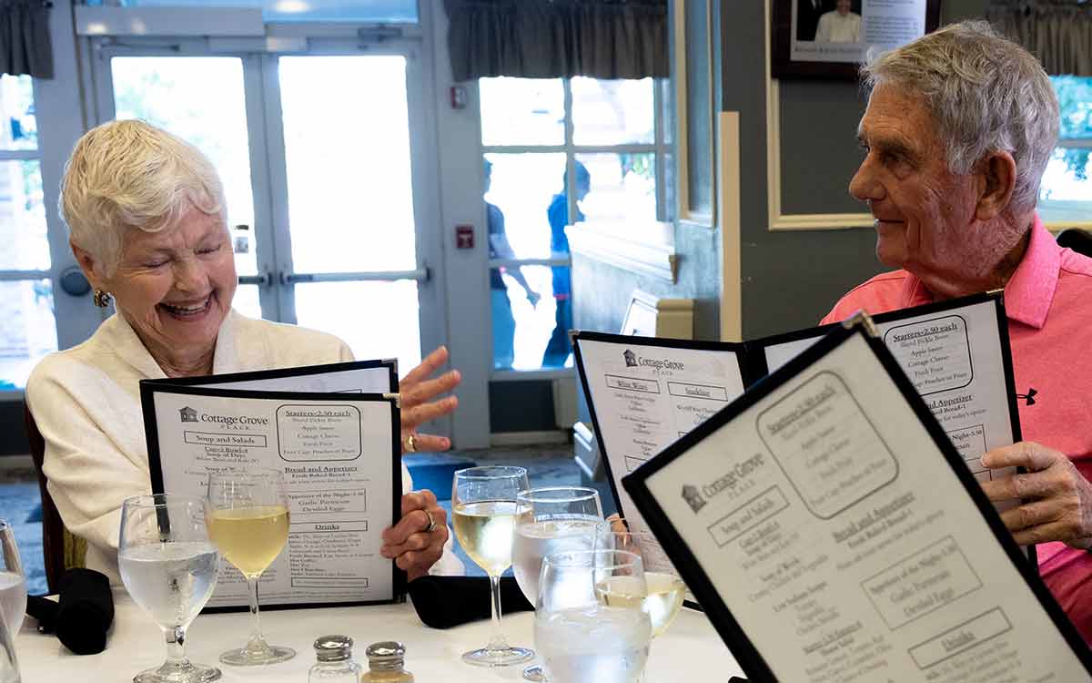 Residents sharing a joyful moment at Cottage Grove Place senior community
