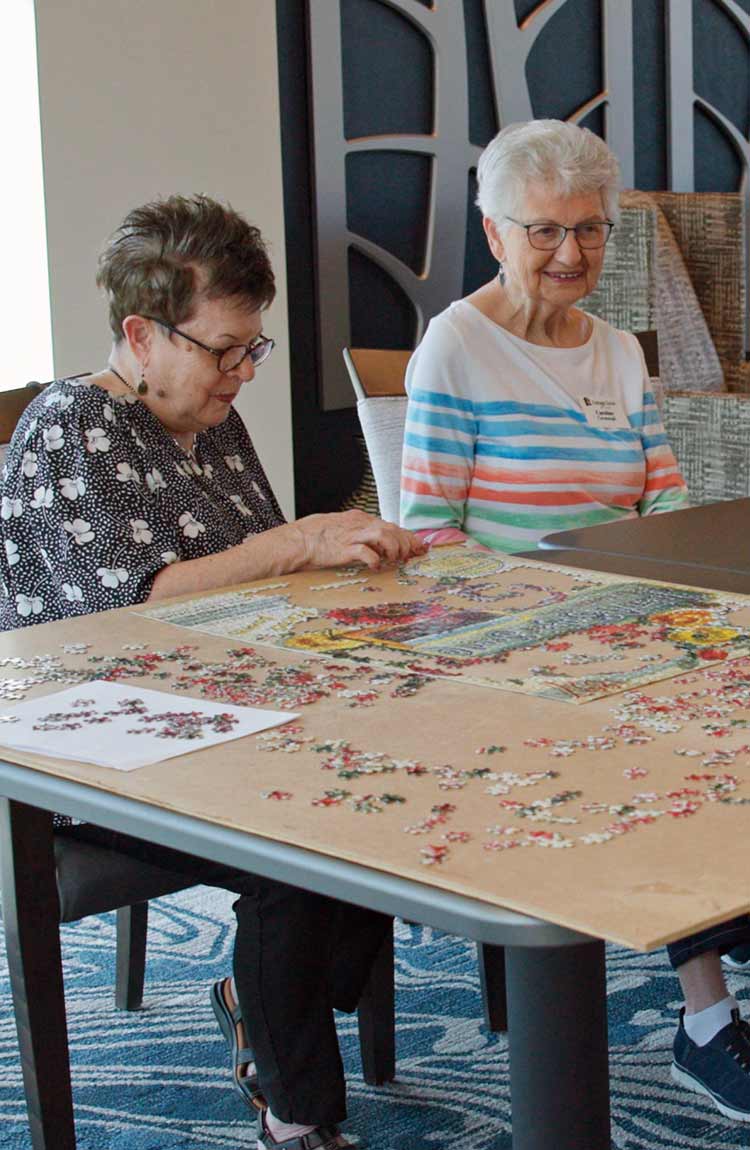 Residents working on a puzzle together at Cottage Grove Place senior living community