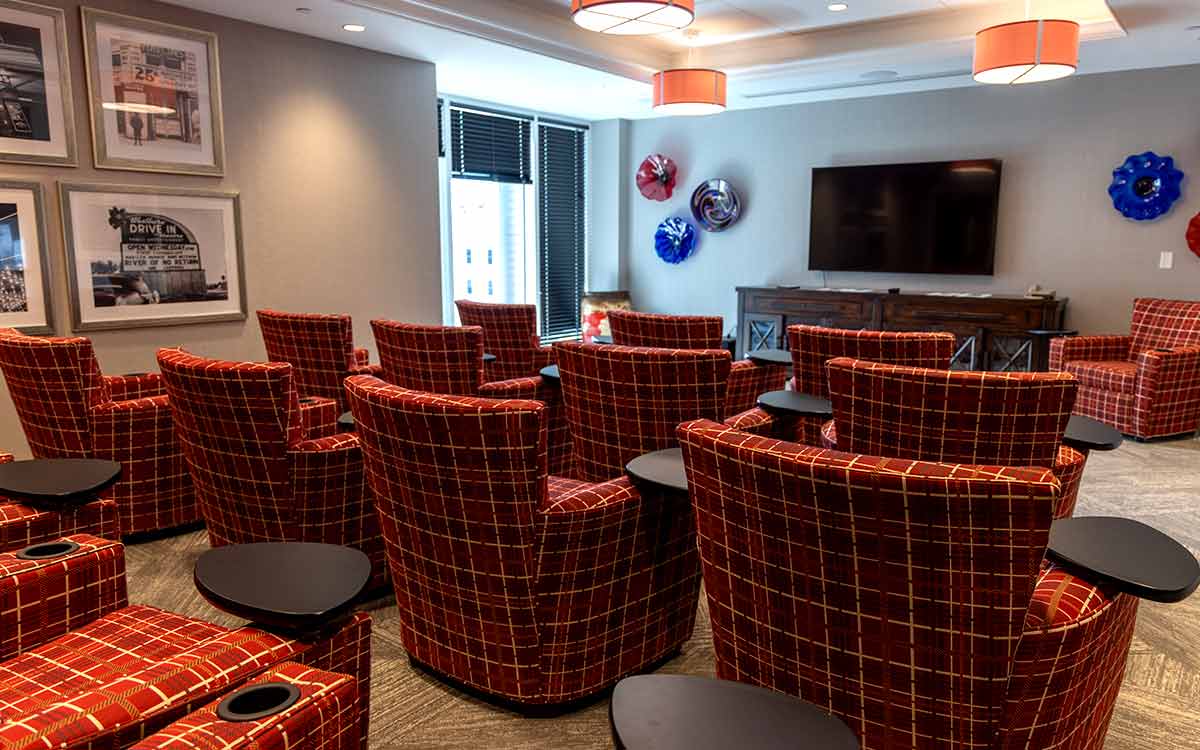 Theater room at Cottage Grove Place senior living community with large screen and comfortable seating