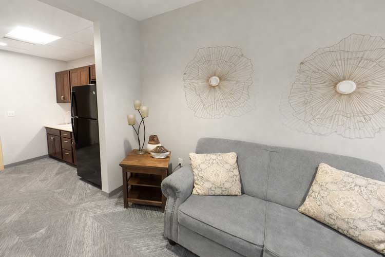 Bright interior of a couch and kitchen of assisted living apartment.